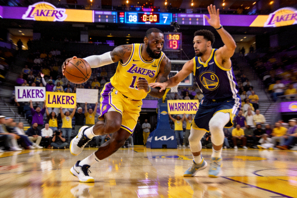NBA湖人队与勇士队比赛现场，詹姆斯持球突破上篮